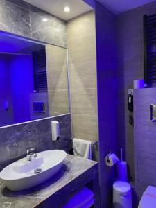 a bathroom with a sink and a mirror and a toilet at Athina Airport Hotel in Thérmi