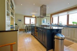 uma grande cozinha com uma grande ilha azul no meio em Albion House- Highlands em Lybster