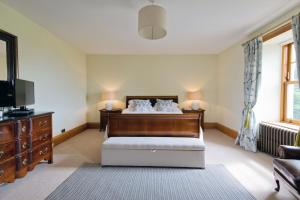 um quarto com uma cama, uma televisão e um sofá em Albion House- Highlands em Lybster