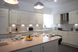 a kitchen with white cabinets and a bowl of fruit on a counter at Whitecraigs in Elgin