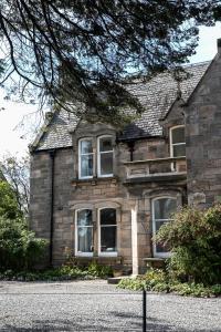 an old stone house with windows on a street at Whitecraigs in Elgin