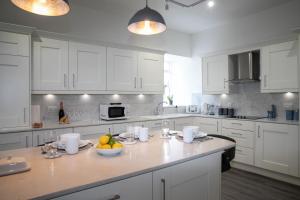 a kitchen with white cabinets and a bowl of fruit on a counter at Whitecraigs in Elgin