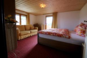 ein Schlafzimmer mit einem Bett und einem Sofa in einem Zimmer in der Unterkunft Kieslinger Hilde in Arrach