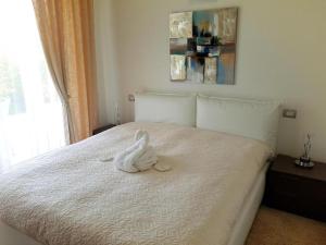 シルミオーネにあるDe Luxe Apartments Dolce Vitaの白いぬいぐるみがベッドに座っている