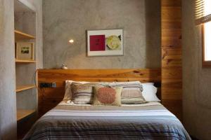 a bedroom with a bed with a wooden headboard and pillows at Sleep y Stay Artistico Loft Sant Daniel in Girona