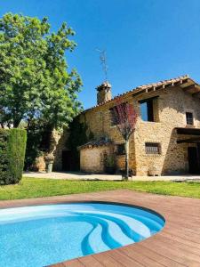 una piscina frente a una casa de piedra en Masia with pool and beautiful views near Girona, en Girona