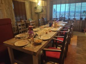 a long wooden table with chairs and plates of food at Folwark i apartameny Malinowy Chruśniak in Bisztynek +59 photos