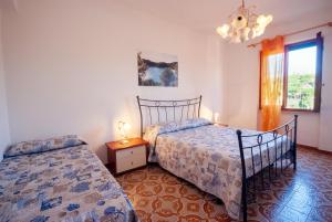 a bedroom with two beds and a window at Appartamenti L'Arcipelago in Marina di Campo