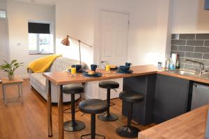 a kitchen with a table and bar with stools at Wisteria 2 bed House - STAYSEEKERS in Salisbury