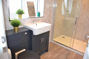 a bathroom with a sink and a shower at Wisteria 2 bed House - STAYSEEKERS in Salisbury
