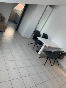 ヴィースバーデンにある3 Room Apartment in Wiesbadenのタイルフロアの客室で、テーブルと椅子が備わります。