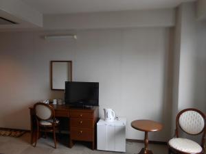 三島市にあるホテルセレクトイン三島 のテレビ、テーブル、椅子が備わる客室です。