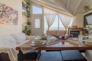 uma sala de jantar com uma mesa e um sofá em Beach Villa Athanasia - villa with private pool on the beach by PosarelliVillas em Acharavi