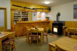 a restaurant with wooden tables and a wood stove at Penzion Apalucha in Dolní Malá Úpa