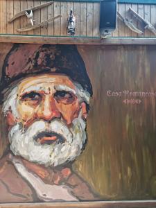 a painting of a man in a hat on a wall at Hotel Casa Romaneasca in Otopeni