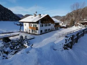 een huis in de sneeuw met een brug bij Garni Hotel Melissa in Castelrotto