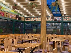 an empty restaurant with wooden tables and chairs at Hotel Casa Romaneasca in Otopeni