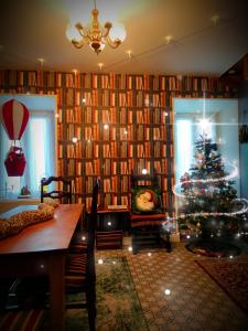 uma sala de estar com uma árvore de Natal em frente a uma biblioteca em La cachette sous l'escalier, le gîte ensorcelé 