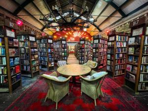 a library with a table and chairs and books at Alnwick Holiday House - Charming, Historic, Central Alnwick with Courtyard in Alnwick