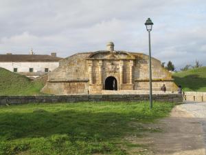 - un vieux bâtiment en pierre sur une colline avec un éclairage de rue dans l'établissement A Muralha, à Almeida