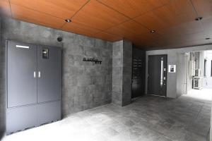 um quarto com uma parede de pedra e dois elevadores em FL Residence Todai II em Tóquio