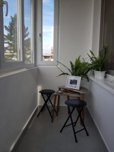 una camera con due sgabelli e un tavolo con un computer portatile di Ana Apartament a Râmnicu Vâlcea
