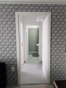 a hallway with a white door leading to a bathroom at Ana Apartament in Râmnicu Vâlcea