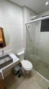 uma casa de banho com um WC, um chuveiro e um lavatório. em Flat Essenciale Style1602 em Goiânia