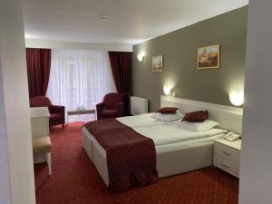 Un pat sau paturi într-o cameră la Hotel Miraj - Restaurant & Sauna & Biliard