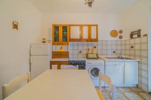 a kitchen with a table and a refrigerator and a washer at Trilocale Naldina a Marciana Marina in Marciana Marina