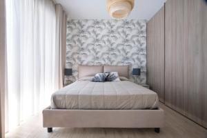a bedroom with a bed and a wall of windows at Italianway - Cristoforo Colombo 12 in San Bartolomeo al Mare