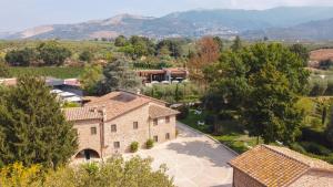 uma vista aérea de uma casa com montanhas ao fundo em Antico Borgo Molino 7cento vicino ai Giardini di Ninfa em Cori