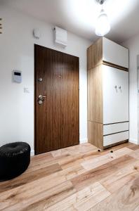 um quarto com uma porta de madeira e um repousa-pés preto em Apartament Boryna em Łomża