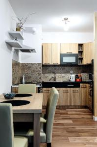 a kitchen with a table and chairs in a room at Apartament Boryna in Łomża