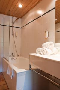 a bathroom with a shower and a sink and towels at Les Crêtes Blanches in Val-d'Isère