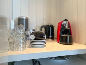 a shelf with cups and plates on it at Van der Gang Suites uniek design in hartje Dokkum in Dokkum +5 photos