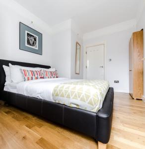 a bedroom with a bed with a black leather couch at Stylish 1 Bedroom Apartment in Amazing Soho Location in London