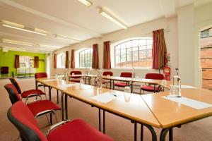 una sala de conferencias con mesas de madera y sillas rojas en YHA Ironbridge Coalport, en Coalport