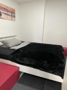 a bedroom with a bed with a black blanket on it at Kastanienallee 7 in Hamburg
