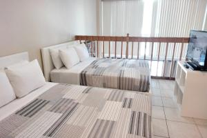 a hotel room with two beds and a television at Miami Beach Apartments by MiaRentals in Miami Beach
