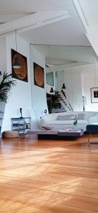 - une grande chambre avec un grand lit et du parquet dans l'établissement Atelier&Loft Arty, à Paris