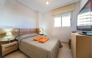 a small bedroom with two beds and a television at Beautiful Apartment In Orpesa Del Mar in Oropesa del Mar +14 photos