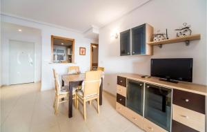 a kitchen and dining room with a table and a television at Beautiful Apartment In Orpesa Del Mar in Oropesa del Mar