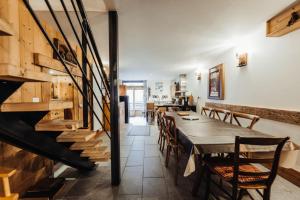 a dining room with a table and chairs and a staircase at Farmhouse with 4 bedrooms 4 bathrooms parking sauna terrace and garden in Chamonix