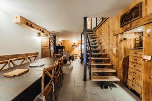 een eetkamer met een lange tafel en een trap bij Farmhouse with 4 bedrooms 4 bathrooms parking sauna terrace and garden in Chamonix-Mont-Blanc