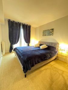 - une chambre avec un lit et une couette bleue dans l'établissement Blue Haven Sèvres, à Sèvres