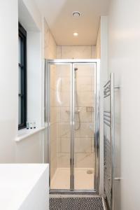 a shower with a glass door in a bathroom at 1 Castle Mews in Salisbury