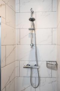 a shower with a shower head in a bathroom at 1 Castle Mews in Salisbury