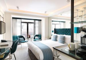a hotel room with a bed and a desk and chairs at The Athenaeum Hotel & Residences in London +82 photos