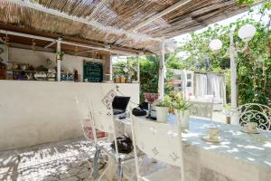 eine Terrasse mit einem Tisch, Stühlen und einer Theke in der Unterkunft Giardino Segreto in Neapel